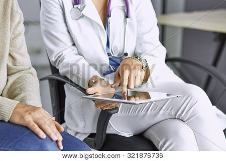 Female Doctor Talking To A Patient On A Tablet