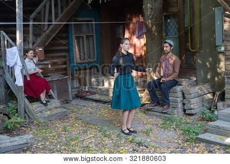 A Pretty Woman Dancing By The Music Near The Country House - A Man Playing Balalaika Sitting On The 