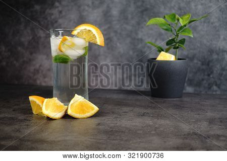 Fresh Water, Oranges And Orange Tree In Pot On Grey Background