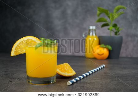 A Glass Of Fresh Orange Juice On Grey Background.