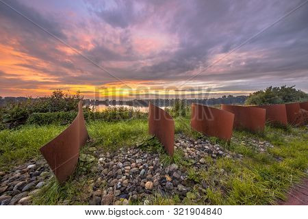 Metal Wave Objects In Landscape With Lake And Sunset At Piccardthofplas Groningen City, Netherlands