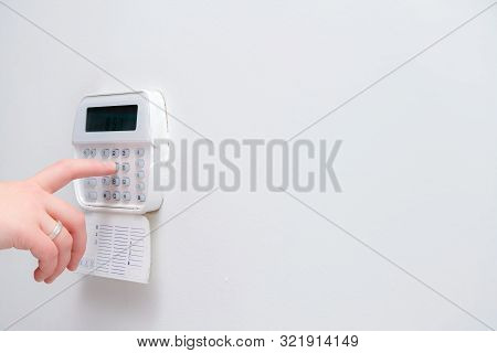 Woman Hand Entering Alarm System Password Of An Apartment, House Of Business Office. Surveillance An
