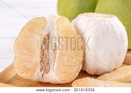 Fresh Peeled Pomelo, Pummelo, Grapefruit, Shaddock On Bright Wooden Table Background. Seasonal Fruit