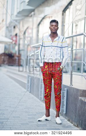Portrait Of Handsome Stylish African American Model Man In Red Throusers And White Shirt.