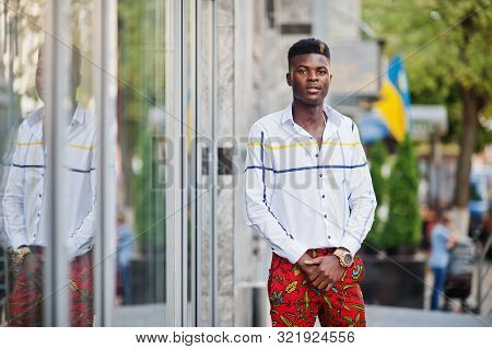 Portrait Of Handsome Stylish African American Model Man In Red Throusers And White Shirt.