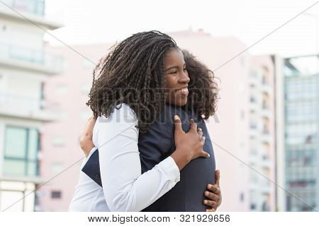 Happy Corporate Female Friends Meeting Outside. Business Women Greeting Each Other In City And Huggi