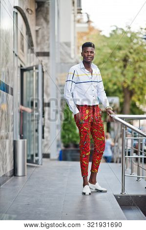 Portrait Of Handsome Stylish African American Model Man In Red Throusers And White Shirt.