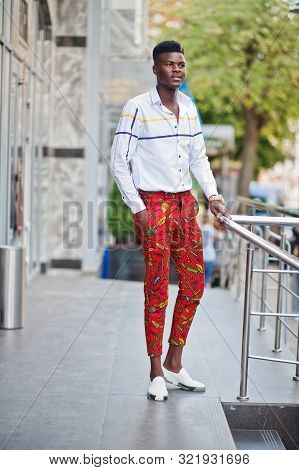 Portrait Of Handsome Stylish African American Model Man In Red Throusers And White Shirt.