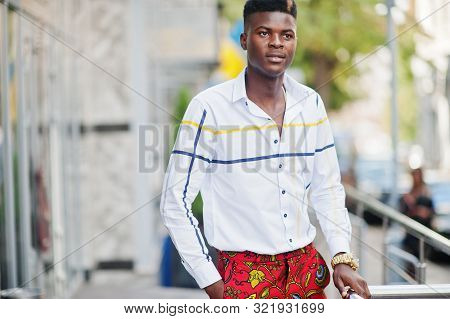 Portrait Of Handsome Stylish African American Model Man In Red Throusers And White Shirt.