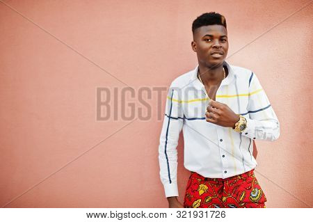 Portrait Of Handsome Stylish African American Model Man In Red Throusers And White Shirt Against Pin
