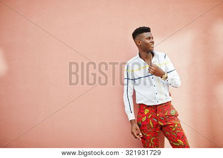 Portrait Of Handsome Stylish African American Model Man In Red Throusers And White Shirt Against Pin