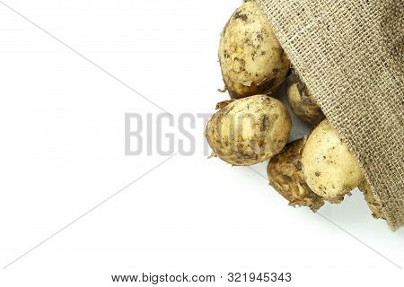 Young Potatoes With The Remains Of Soil On A Peel In Burlap. Heap Isolated On A White Background. Sp