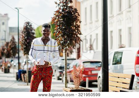 Portrait Of Handsome Stylish African American Model Man In Red Throusers And White Shirt With Cell P