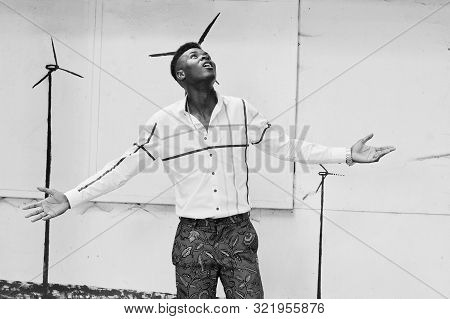 Portrait Of Handsome Stylish African American Model Man In Red Throusers And White Shirt. Raised His