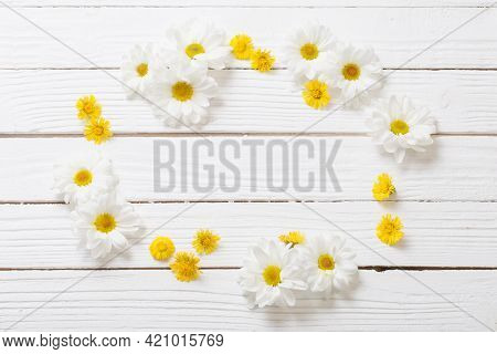 White Chrysanthemum And Yellow Coltsfoot On White Wooden Background