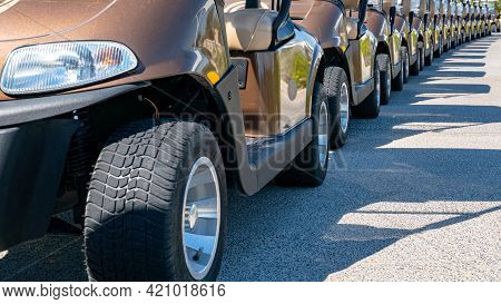 A Row Of Electric Golf Carts On A Golf Course.