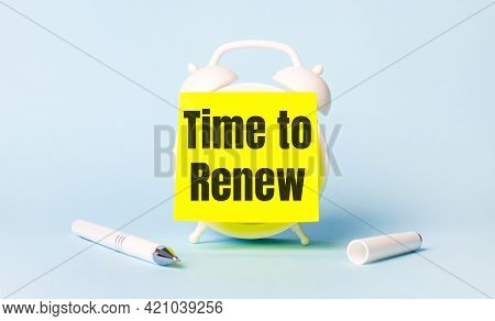On A Light Blue Background - A White Handle And An Alarm Clock With A Bright Yellow Sticker Glued To