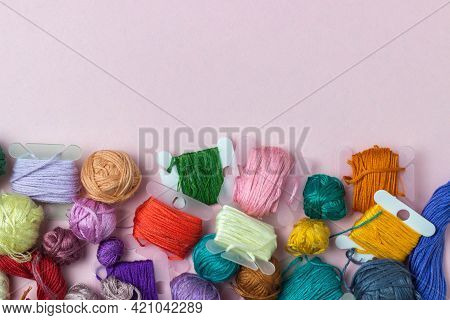 Rolls Of Thread Mulin Of Different Colors On A Pink Background With Copy Space. Hobbies, Embroidery,