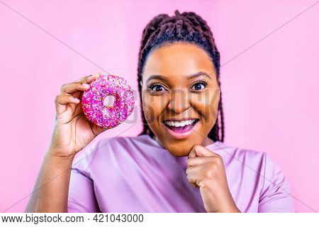 Woman Showing Donut Eyas Glasses In Pink Studio Background