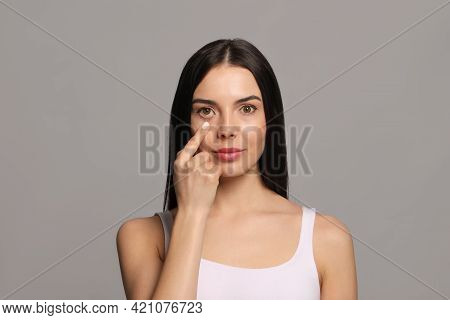 Woman Checking Her Health Condition On Grey Background. Yellow Eyes As Symptom Of Problems With Live