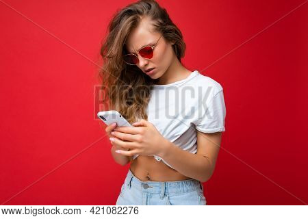 Photo Of Beautiful Young Woman Holding Mobile Phone Wearing Sunglasses Everyday Stylish Outfit Isola