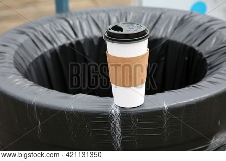 May 14, 2021 Santa Monica California, USA: Generic paper coffee cup on the side of a trash can with a plastic liner. Paper Coffee Cups are used world wide to drink coffee and soda. Editorial Use. 