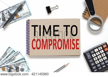 Time To Compromise. Notebook On White Workspace. Near The Notepad Dollar Bills And A Calculator