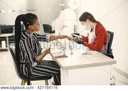 African Girl Doing Manicure In A Beauty Salon
