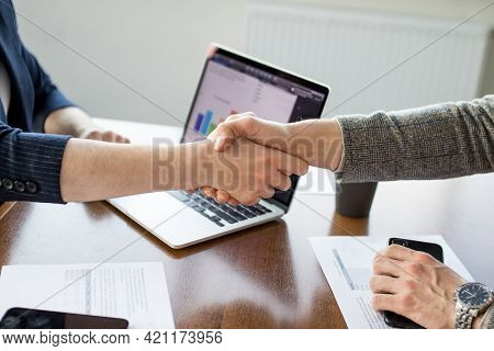 Close Up Of Young Businessman And Businesswoman Making The Fist Bump On Building Background. Busines
