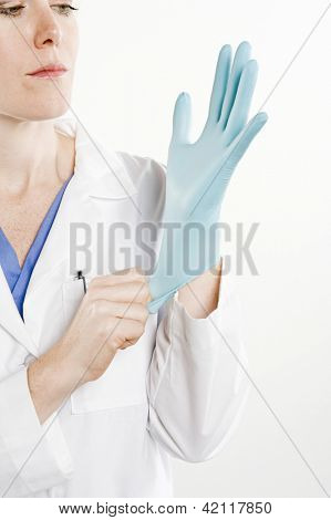 Ženský lékař nosit rukavice sterilizované ruku izolovaných na bílém pozadí