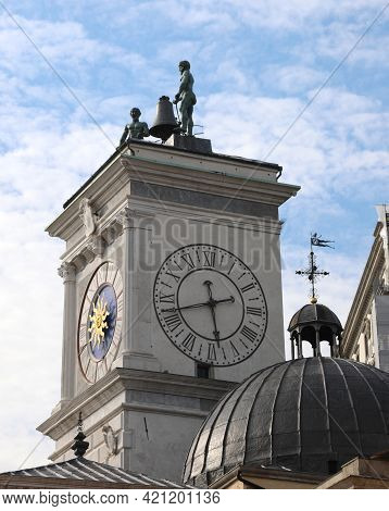 Detail Of The Famous Clock Tower And Two Bronze Statues Above In The Main Square Of The City Of Udin