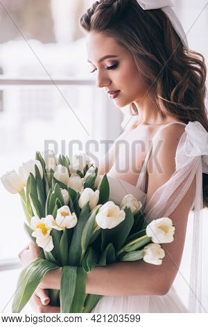 Wedding Bouquet Of White Tulips In The Hands Of A Beautiful Bride. Selective Focus