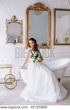 Beautiful Brunette Bride Posing In White Dress With Wedding Bouquet In Studio