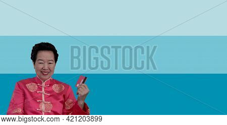 Chinese New Year Spending Credit Card. Asian Senior Woman In Constume Holding Red Card