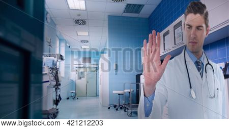Caucasian male doctor touching invisible screen against hospital in background. medical research and technology concept