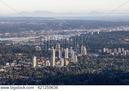 Aerial View From Airplane Of Residential Homes And Buildings In A Modern City During Sunny Evening. 