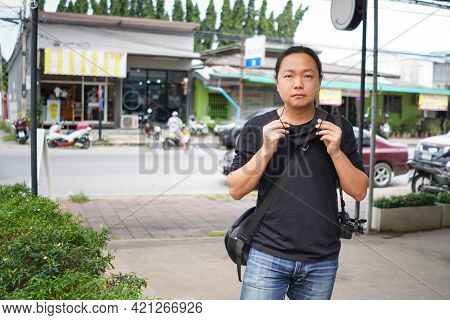 Asian Man In Black T-shirt And Jean Trousers Is Wearing Black Face Mask In Front Of Blure Thailand C