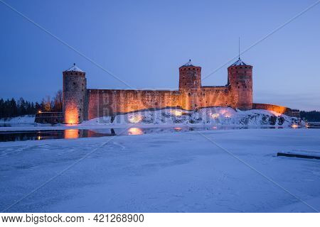 Ancient Fortress Olavinlinna In Night Illumination On A March Twilight. Savonlinna, Finland