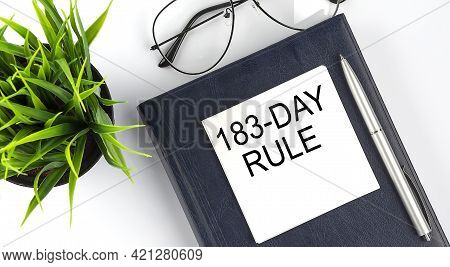 Stickers On Notebook Text 183-day Rule With Pen And Glasses On The White Background