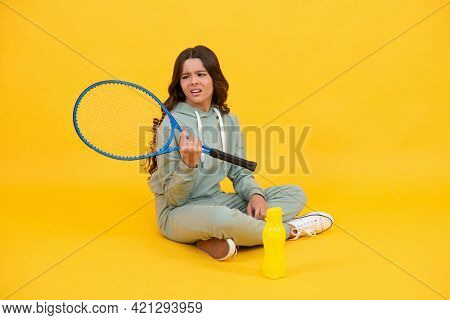 Unhappy Kid Sit With Racket Water Bottle. Child With Tennis Racquet. Teen Girl Going To Drink Water