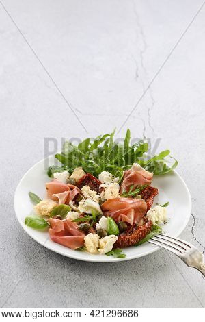 Salad Arugula, Parma Ham With Sun-dried Tomatoes, Mozzarella Slices, Croutons, Capers, Seasoned Oil 