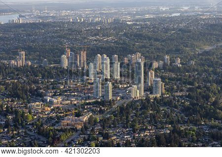 Aerial View From Airplane Of Residential Homes And Buildings In A Modern City During Sunny Evening. 