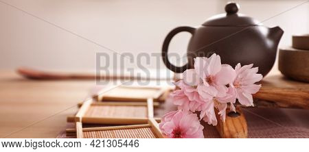 Pot, Sakura Flowers And Bamboo Coasters For Traditional Tea Ceremony On Table. Banner Design