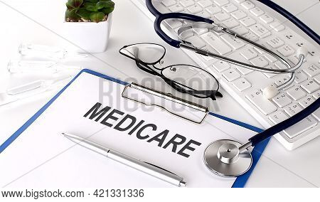 Medicare Text On White Paper On The White Background. Stethoscope ,glasses And Keyboard