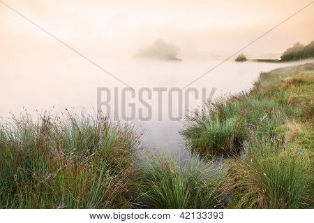 Krásný podzim podzim krajina nad mlhou Misty Lake Wih zářící barvy Sunrise