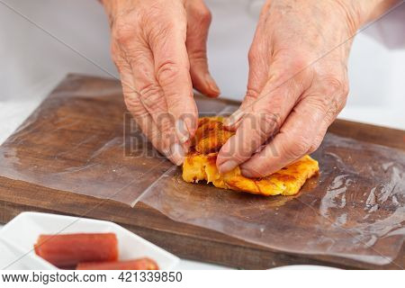 Senior Woman Preparing A Traditional Dish From El Valle Del Cauca In Colombia Called Aborrajado