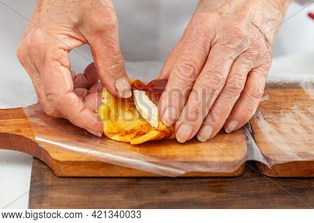 Senior Woman Preparing A Traditional Dish From El Valle Del Cauca In Colombia Called Aborrajado
