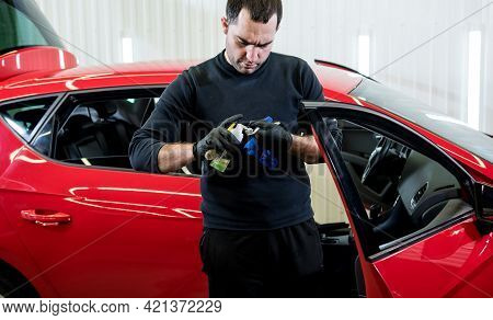 Car Service Worker Cleans Interiror With Special Brush