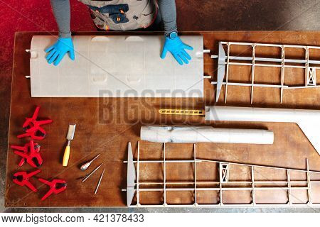 Top View Image Of Young Male Engineer Or Technician Working On Drone Details In Lab. Plane Wing. Wor