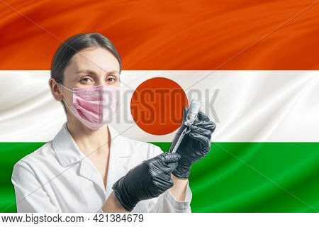 Girl Doctor Prepares Vaccination Against The Background Of The Niger Flag. Vaccination Concept Niger